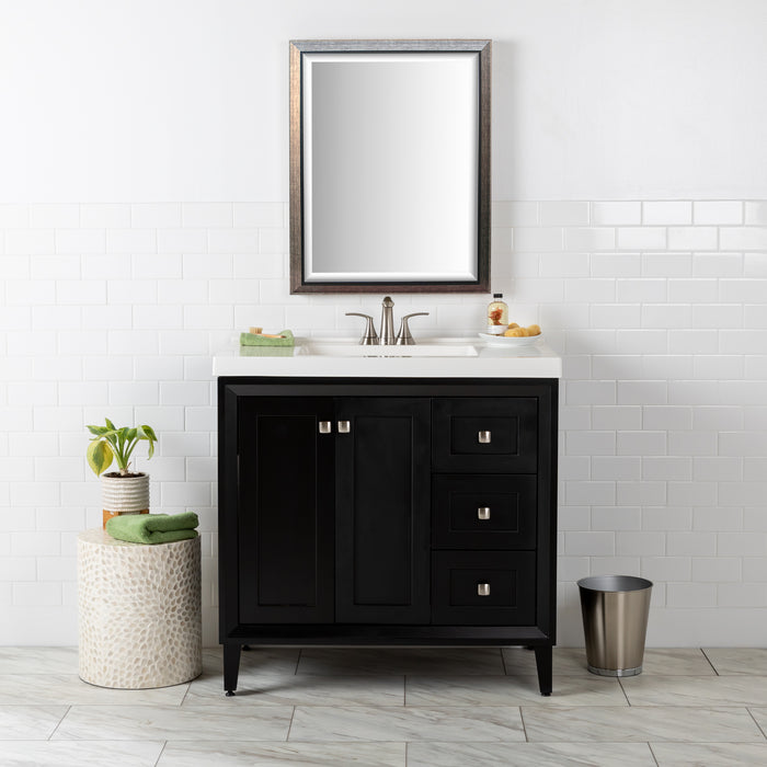 Front view of the Beckett 37" wide powder room vanity with black cabinet finish, white sink top, 2 soft-close doors, 3 drawers, and fine grain nickel pulls. Shown with mirror, soap dish, hand towel and other bathroom items.