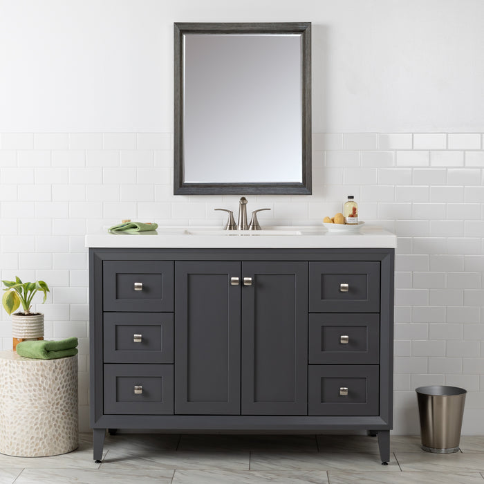 Front view of the Beckett 49" wide furniture-style bathroom vanity with gray cabinet finish, white sink top, 2 soft-close doors, 6 drawers, and fine grain nickel pulls. Shown with mirror, soap dish, hand towel and other bathroom items.