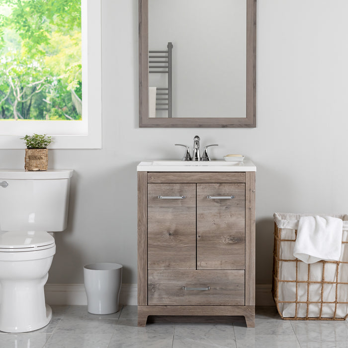 24.25 in Breena bathroom vanity with woodgrain laminate finish, 2-door cabinet, base drawer, chrome hardware installed in bathroom with faucet and mirror