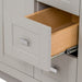 Open drawer on Lonsdale 36 inch warm gray powder room vanity with 2 doors, 3 drawers, and white top with offset sink