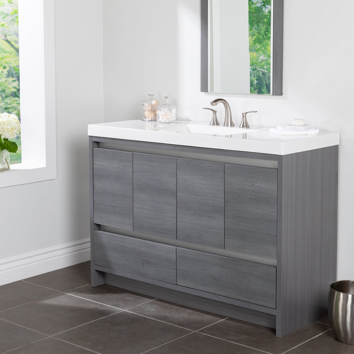 Trente 48 inch 4-door, 4-drawer, hardware-free bathroom vanity with woodgrain finish and white sink top installed in bathroom.