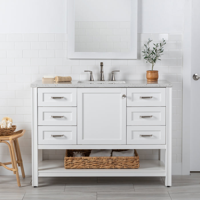 48 in. Eaton white bathroom vanity with cabinet, 6 drawers, open shelf, adjustable legs, and brushed nickel handles with granite-look sink top installed in bathroom with faucet and mirror