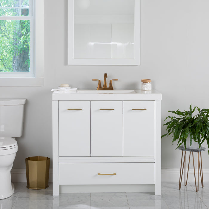 Hali 36.5 white bathroom vanity with 3 doors, 2 drawers, brushed gold hardware, white sink top installed in bathroom with faucet and mirror